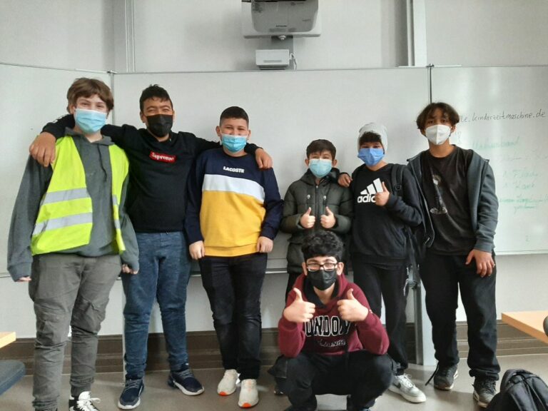 Sieben Schüler stehen mit Masken nebeneinander.