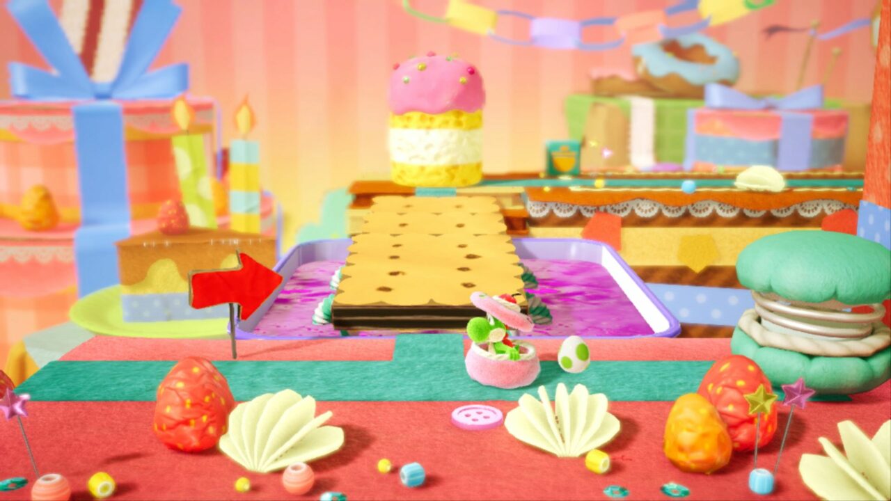 In einer bunten Kuchenfabrik schaut Yoshi aus einem Törtchen.