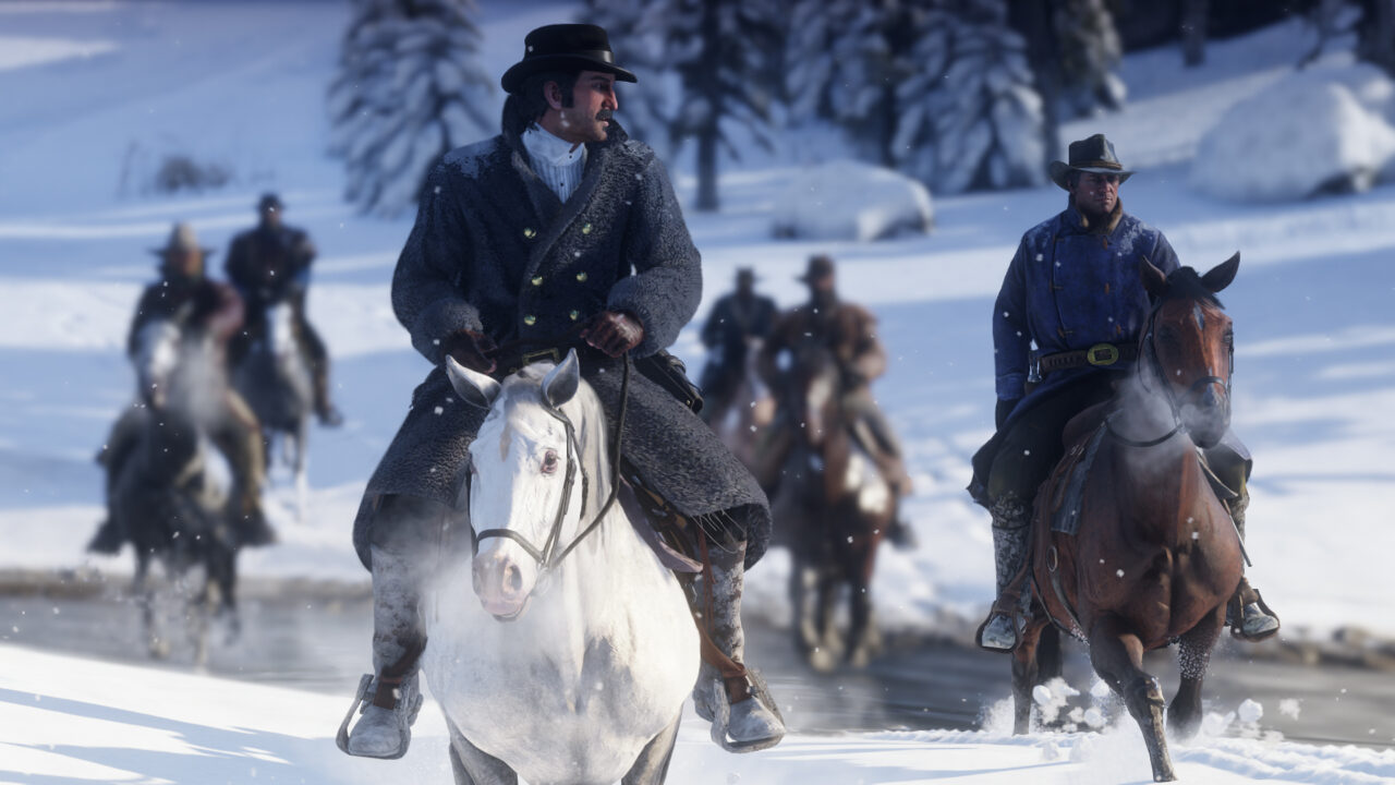 Mehrere Personen reiten auf ihren Pferden durch eine Schneelandschaft.