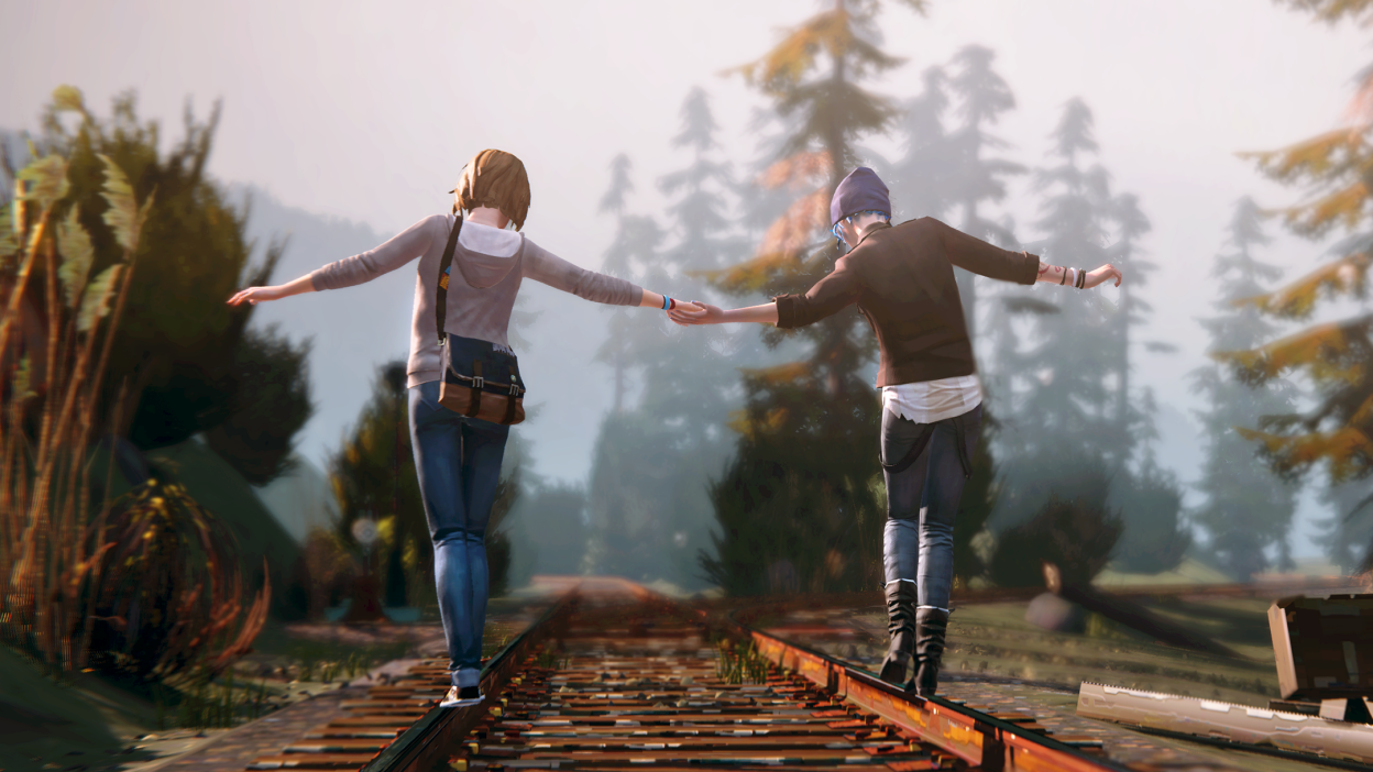 Ansicht von hinten auf Hauptprotagonistin Max und Chloe aus Life is Strange. Sie balancieren auf den Schienen eines Eisenbahngleises und halten sich dabei an der Hand.